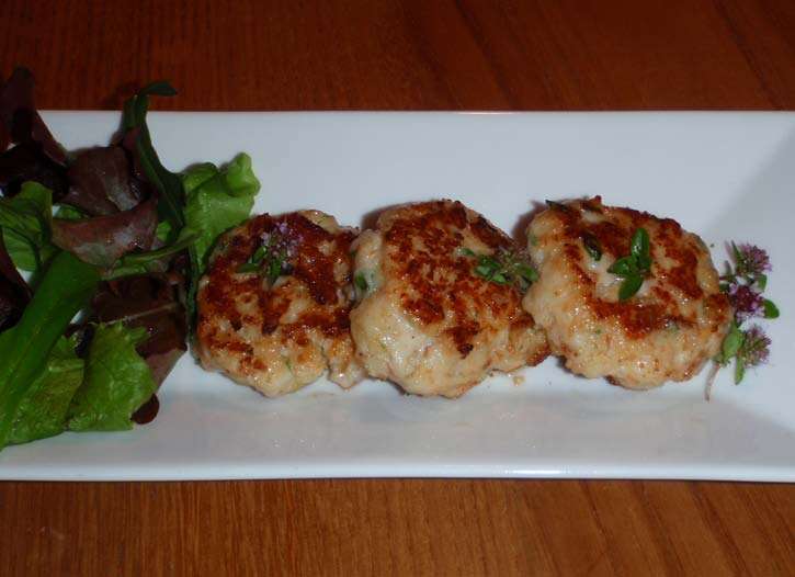 Drei Fischburger mit grünem Salat und Thymianblüten