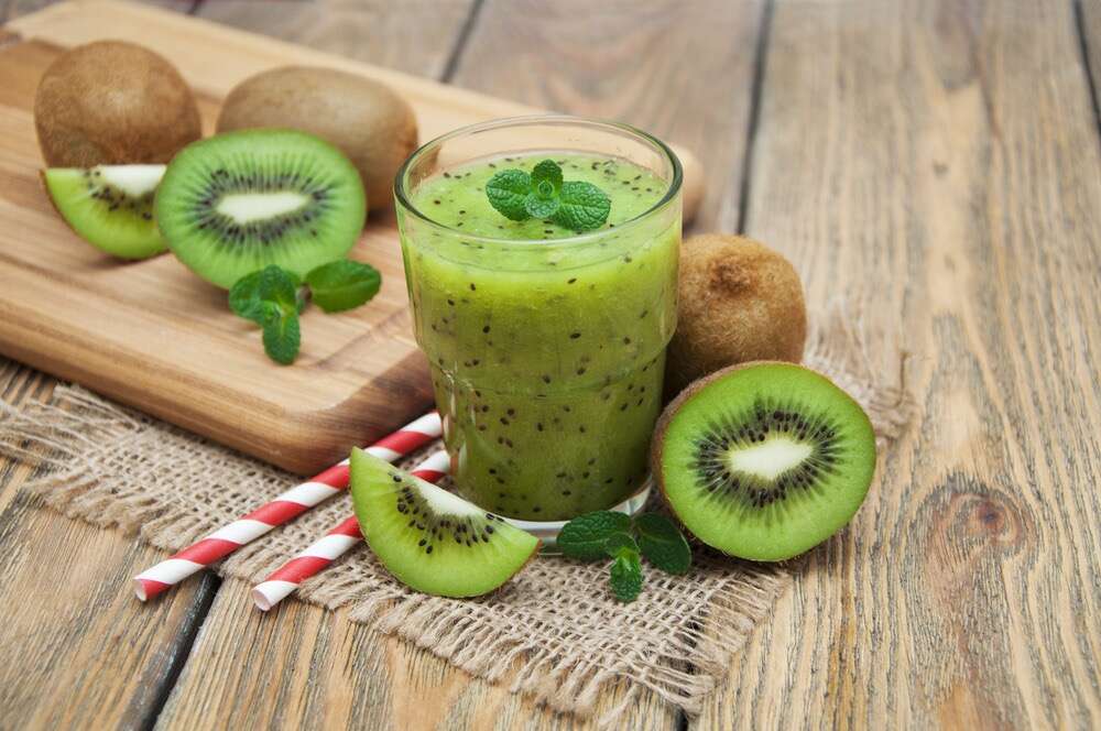Ganze und geschnittene Kiwis und Kiwi-Smoothie