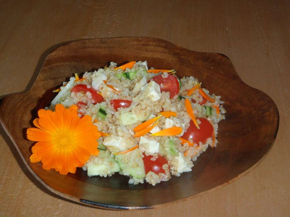 Bulgursalat mit Ringelblumen-Blüten auf Teller