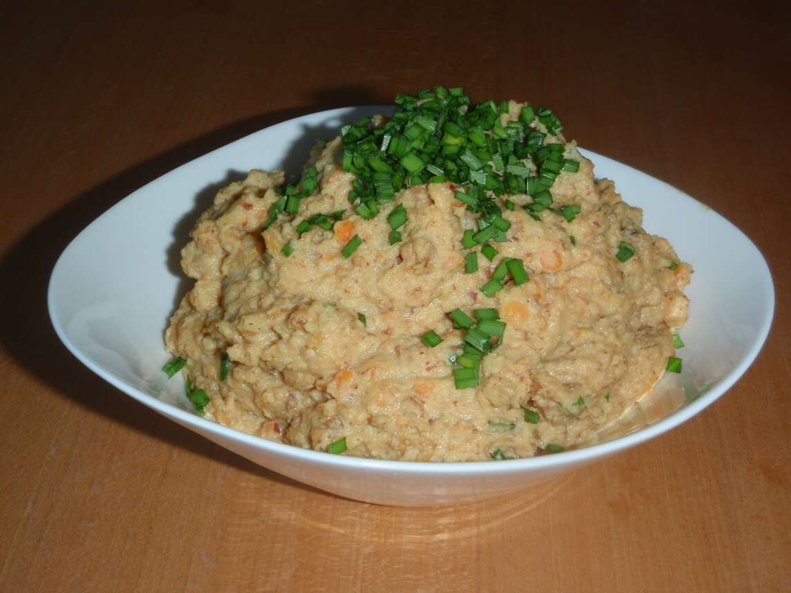 Teller mit Linsenhummus und geschnittenem Schnittknoblauch
